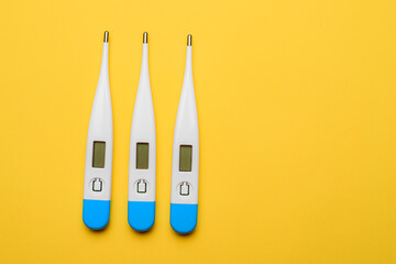 Electronic thermometers . Electronic thermometer on a yellow background. Temperature measurement. Safe thermometer. Modern medical equipment. Science and medicine. Article about safe thermometers. Tec