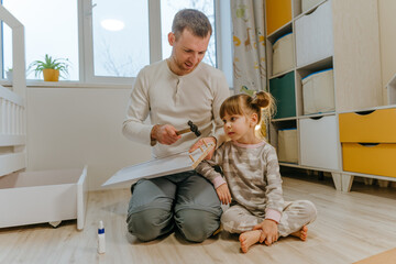 Daughter helping her father fix the drawer of kids bed