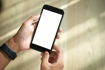 Close up view of male hands using smart phone with modern office blurred background. Blank screen monitor for graphic display montage.