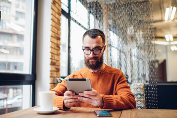 Smiling man using tablet for watching video