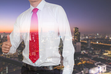Double exposre of businessman give a thumbs up for compliment and light night urban background as...