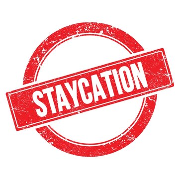 STAYCATION text on red grungy round stamp.