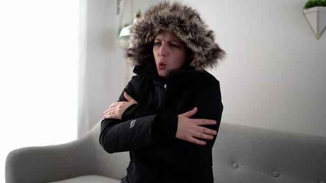A woman With Warm Clothing Feeling The Cold Inside House on the sofa