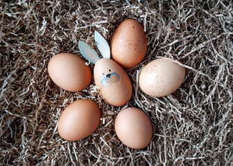 Funny chicken eggs for easter. Top view. Background with Easter Eggs. Close up of eggs in a basket. top view of eggs in bowl. Brown eggs in wooden bowl. 