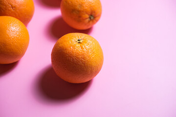 various oranges on an exotic background. oranges on a pink background
