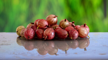 Ripe gooseberries on a table with a wet surface