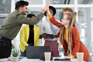 Mixed race people giving high five after successful meeting