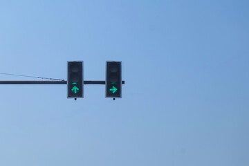 Green traffic lights on the road with blue sky.