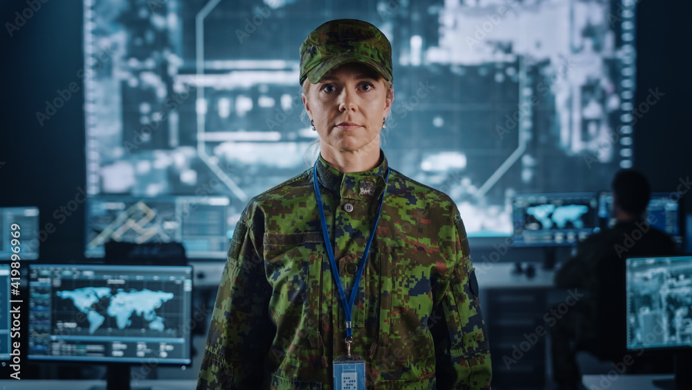 Poster female military officer posing in front of the camera. she in standing in surveillance cyber operati