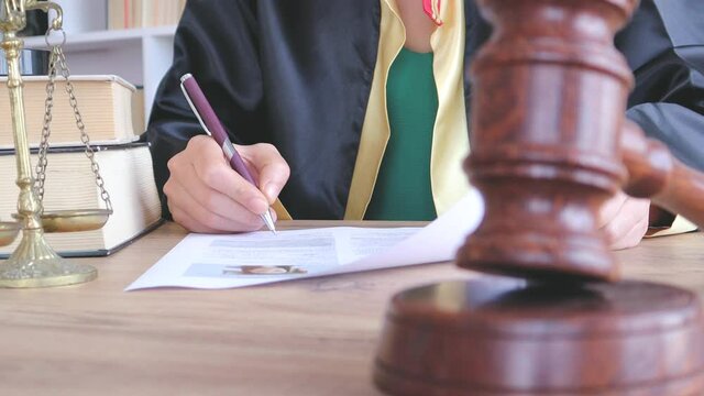 Woman lawyer working with contract papers and wooden gavel on tabel in courtroom. justice and law ,attorney, court judge, concept.