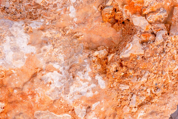 Light red-orange stone texture. Red orange grunge background. Mountain texture macro close-up. Bright colorful banner for your design.