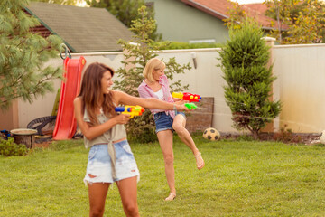 Young friends having a squirt gun fight