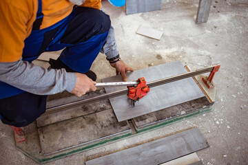 Handyman cutting ceremic tiles on the flor