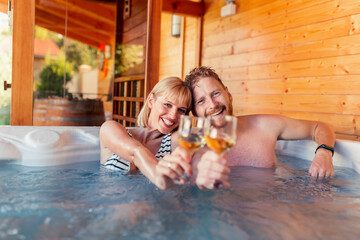 Couple making a toast and relaxing in a hot tub