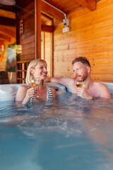 Couple drinking wine and relaxing in a hot tub