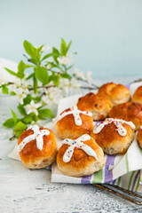 Homemade Easter traditional hot cross buns and painted eggs on a gray background