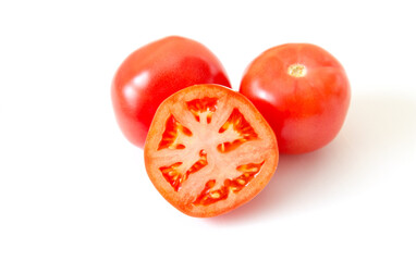 Group of fresh ripe red tomatoes, sliced and whole, isolated on white background.