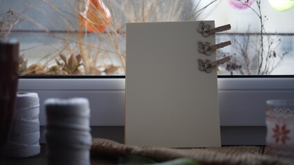 Kartka papieru pastelowa na parapecie przy oknie w dzień - obrazy, fototapety, plakaty