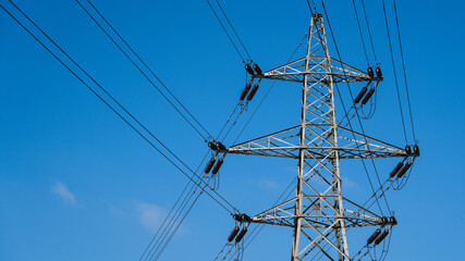 High voltage power lines on a blue sky background