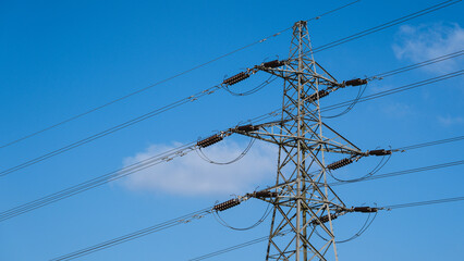 High voltage power lines on a blue sky background