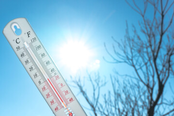 The thermometer lies on the snow and shows a negative temperature in cold weather on the blue sky.Meteorological conditions with low air and ambient temperatures.Climate change and global warming