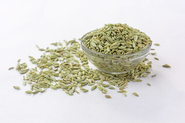 Dried organic fennel seeds or saunf in a glass bowl on white isolated background.