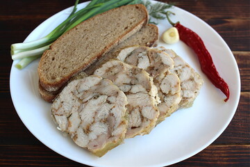 A white plate contains ham, bread and spices