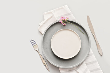 empty grey plates on a table with fork and knife. spring menu concept. trendy nordic minimal style tableware. restaurant menu mock up. top view, copy space. scandinavian tableware design