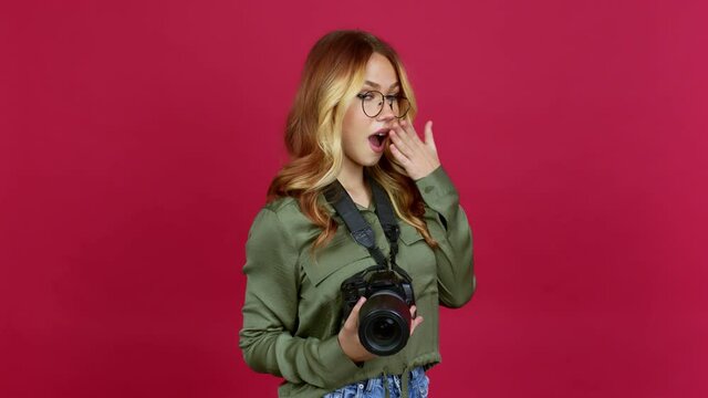 Young blonde girl photographer pointing to the side and presenting a product while smiling over isolated background