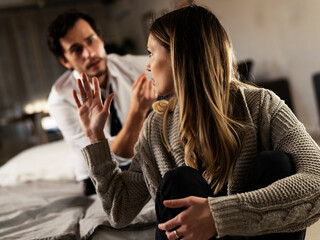 Husband and wife are arguing at home. Angry man is yelling at his wife.