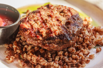 Macro of buckwheat porridge with meat patty. Top view, close up, stock photo