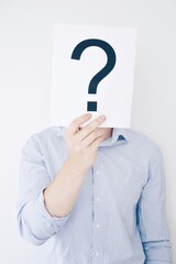 A man holding a question mark in front of head