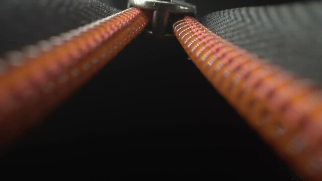 The orange line of the zipper while opening the luggage bag on a closer look in Estonia