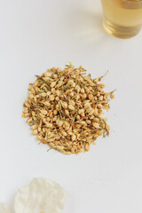 Jasmine green tea, dried jasmine and a cup of green jasmine tea on white background.  Top view, copy space, stock photo