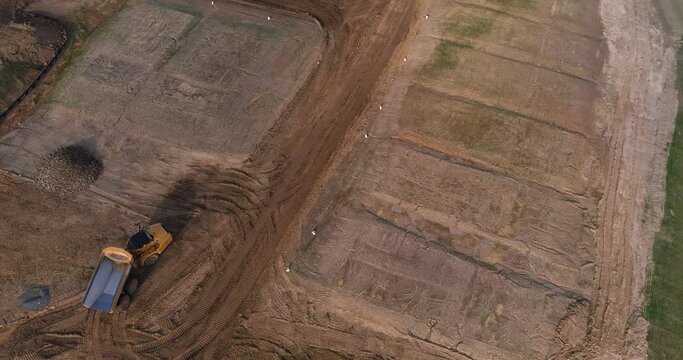Drone shot of empty dump truck turning at construction site