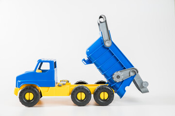 Plastic car. Toy model isolated on a white background. Yellow-blue truck with a body.