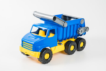 Plastic car. Toy model isolated on a white background. Yellow-blue truck with a body.