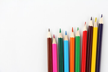 A set of colored pencils on a white background. Back-to-school concept, stationery, drawing supplies, creativity. Copyspace.