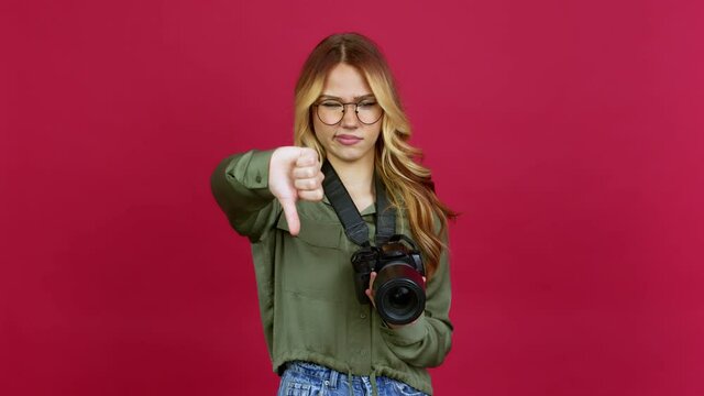 Young blonde girl photographer doing bad signal over isolated background