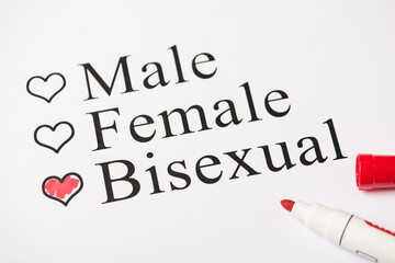 Above photo of red color marker and paper with text male female and bisexual isolated on the white background