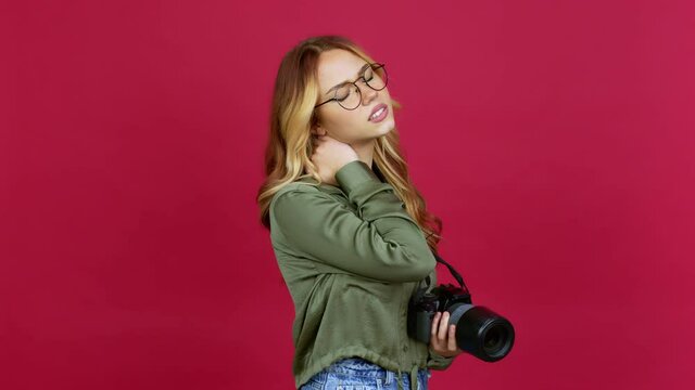 Young blonde girl photographer with neck pain over isolated background