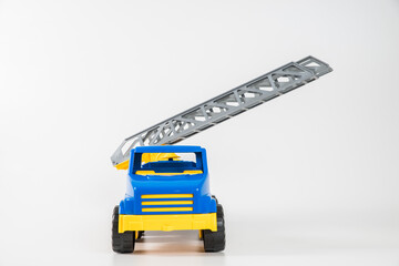 Plastic car. Toy model isolated on a white background. Yellow-blue truck with fire escape.