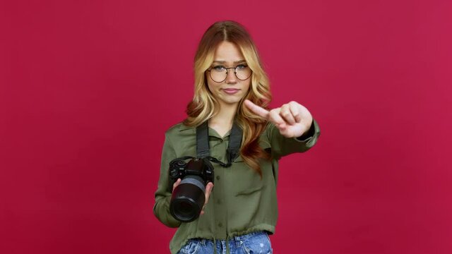 Young blonde girl photographer doing NO gesture over isolated background