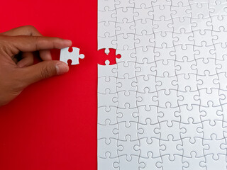 Hand put the last of jigsaw puzzle to complete the mission.