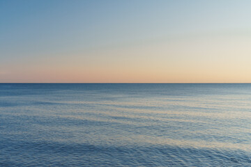 Fototapeta na wymiar The horizon dividing the sea and the sky into equal parts at sunset.