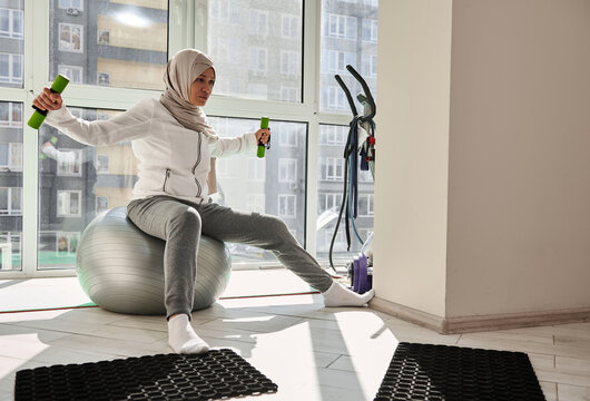 Beautiful Muslim Woman In Hijab Working Out At Home. Healthy Lifestyle.