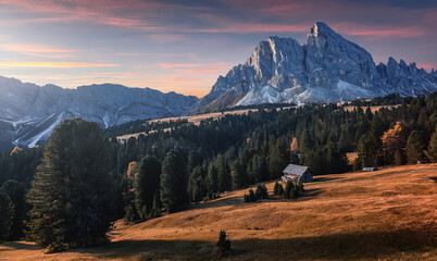 Stunning alpine Landscape at autumn. Small hunter hut on Alpine meadow near forest and mountain on...