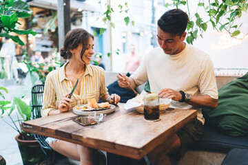 Content young couple enjoying lunch in outdoor cafe