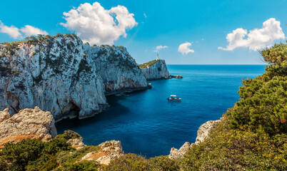 Beaotiful View of the Lighthouse on the cliff. sunny seascape of Cape Lefkatas with old lighthouse in summer day. Wonderful picturesque vivid landscape over the Ionian Sea. Lefkada island. Greece.