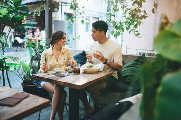Young couple having lunch and chatting in cafe